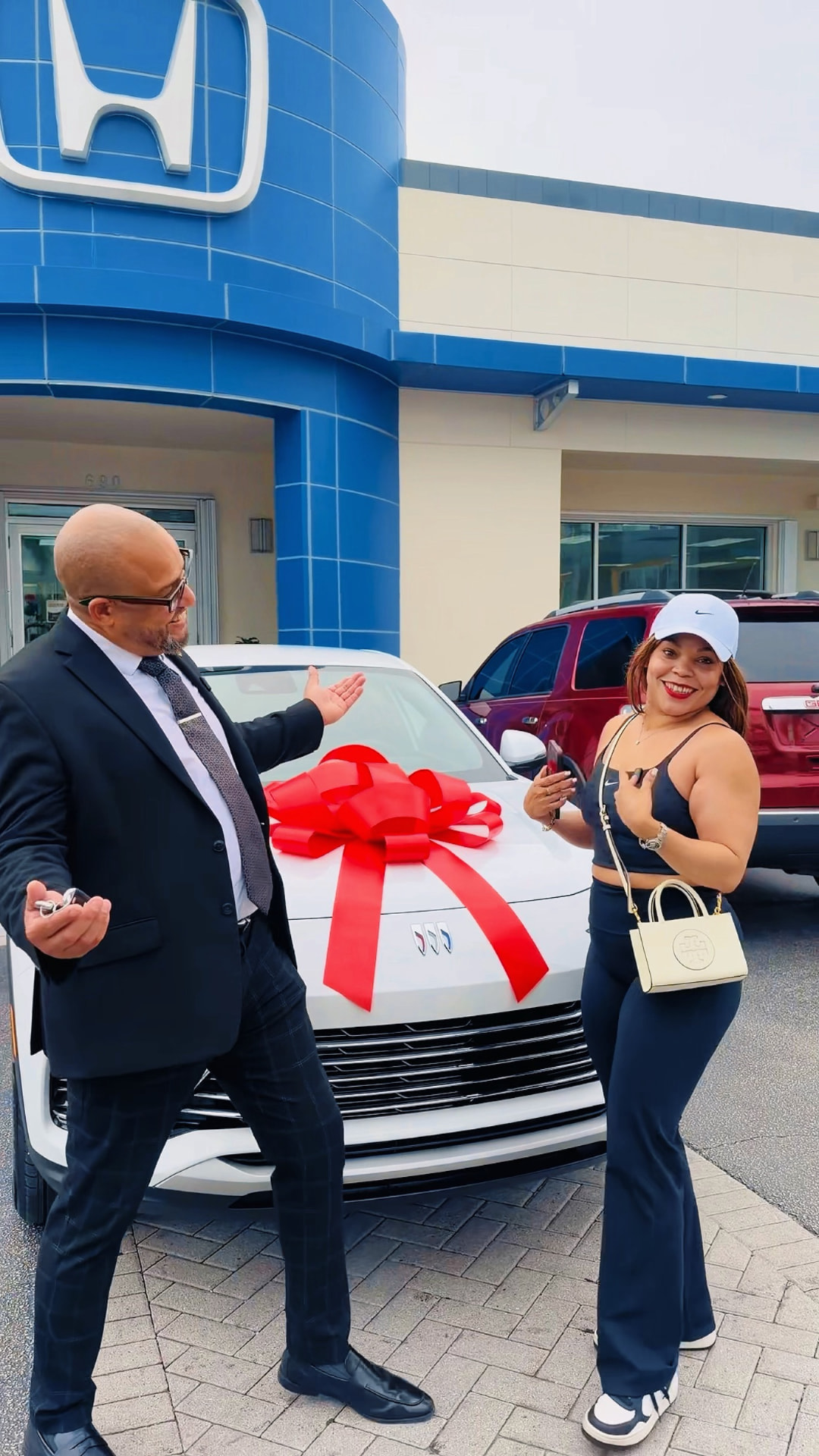 Customer receiving new vehicle keys with a red delivery bow